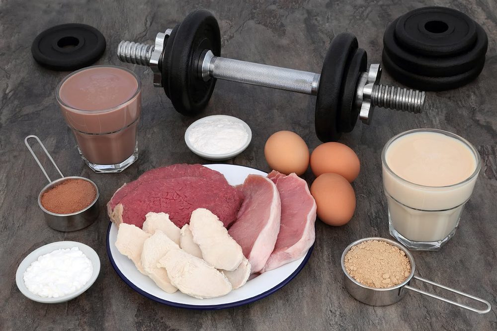 High-protein foods, shakes and a dumbbell for nutrition coaching
