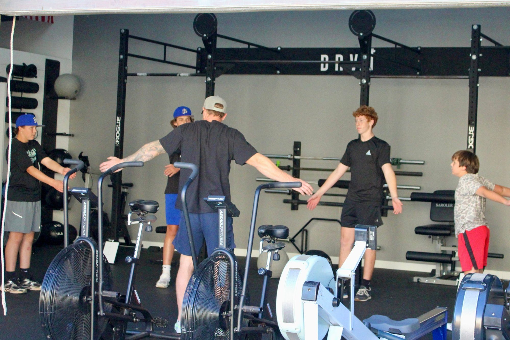 A DRVN coach leading youth athletes through a warm-up at the Surfside Beach gym